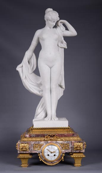 Peach blossom marble and gilt bronze clock surmounted by a statuary white marble sculpture representing Phryne in front of his judges signed Peach blossom marble and gilt bronze clock surmounted by a statuary white marble sculpture representing Phryne in front of his judges signed