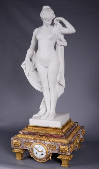 Peach blossom marble and gilt bronze clock surmounted by a statuary white marble sculpture representing Phryne in front of his judges signed Peach blossom marble and gilt bronze clock surmounted by a statuary white marble sculpture representing Phryne in front of his judges signed