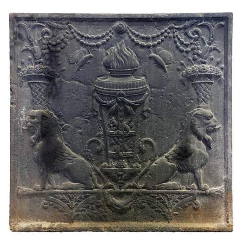 Fireback of the 18th century depicting a vase on a tripod with fire framed by two chimeras supporting baskets of fruit