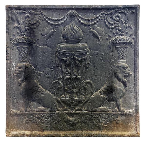 Fireback of the 18th century depicting a vase on a tripod with fire framed by two chimeras supporting baskets of fruit Fireback of the 18th century depicting a vase on a tripod with fire framed by two chimeras supporting baskets of fruit-0