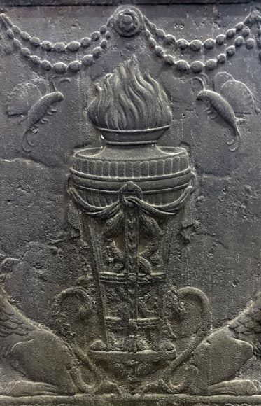 Fireback of the 18th century depicting a vase on a tripod with fire framed by two chimeras supporting baskets of fruit Fireback of the 18th century depicting a vase on a tripod with fire framed by two chimeras supporting baskets of fruit-1