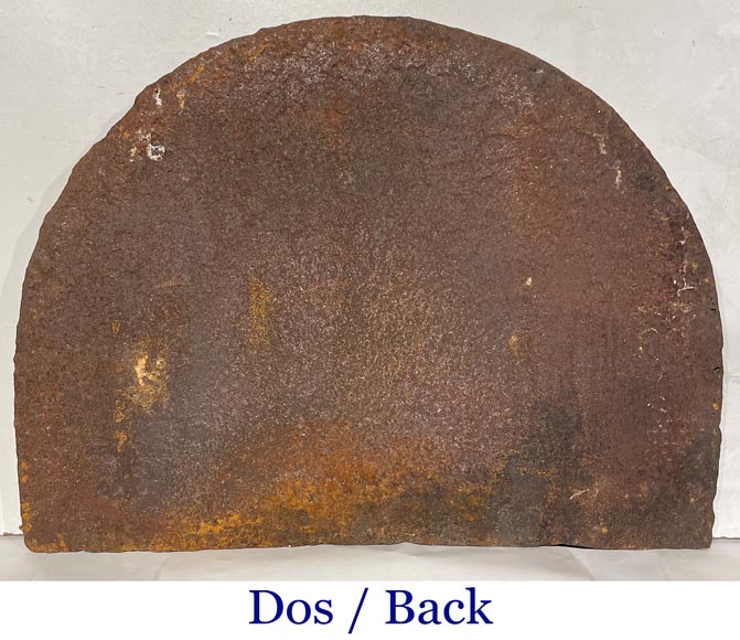 A semicircular cast iron fireplace plaque, decorated with a coat of arms, surmounted by a helmet and framed by lions.-6