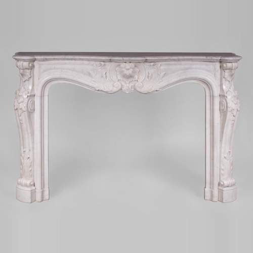 Beautiful antique Louis XV style fireplace with rich decor in white Carrara marble