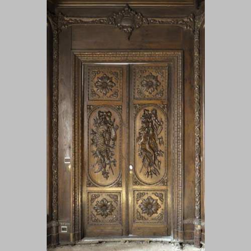 Large antique carved oak wood paneled room with hunting trophies and still lifes decor