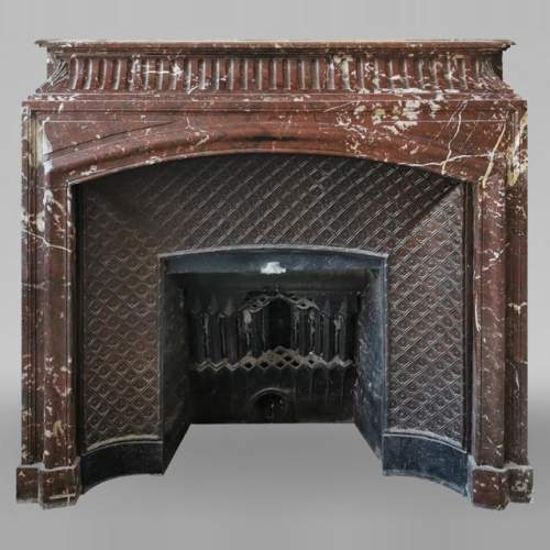 Louis XIV style mantel with an acroterion in Red of the North marble