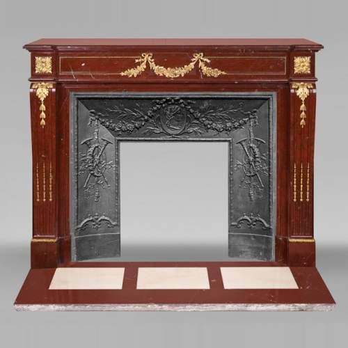 Louis XVI style fireplace in Antique Red marble, with bronze mounts, decorated with a garland