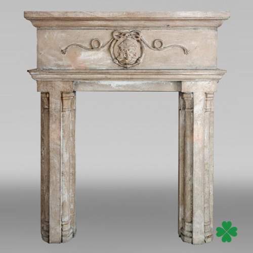 Carved stone fireplace with three-faced mask decoration