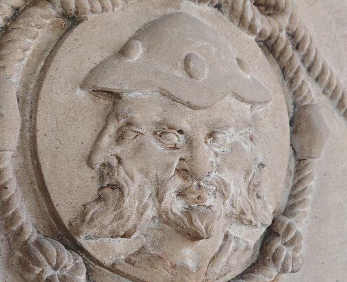 Carved stone fireplace with three-faced mask decoration-1