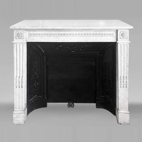 Louis XVI style fireplace in Carrara marble, decorated with ribbons and floral rosettes