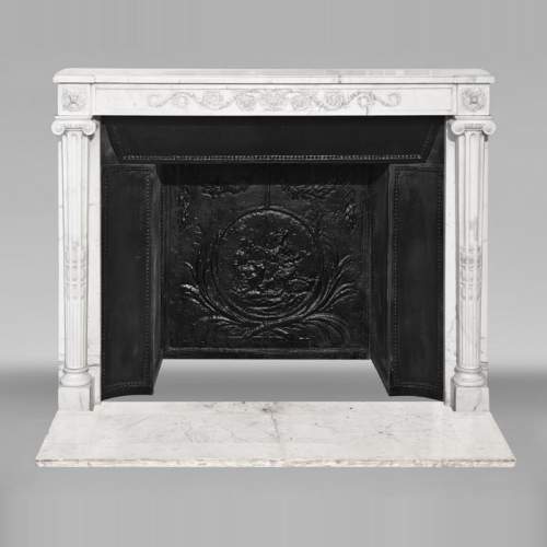 Louis XVI style fireplace in semi-statuary marble, featuring columns and Ionic capitals