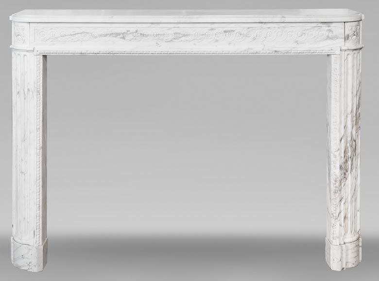 A Louis XVI period fireplace in veined Carrara marble, decorated with a Greek-style frieze.-0