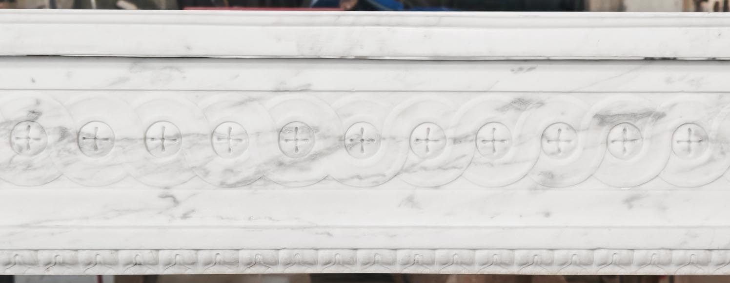 A Louis XVI period fireplace in veined Carrara marble, decorated with a Greek-style frieze.-1